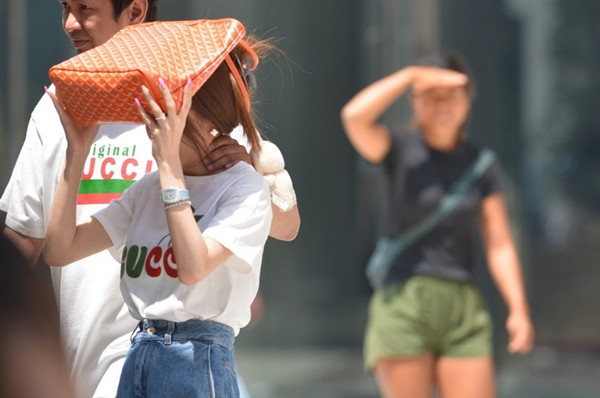 Người đi bộ che nắng trong một đợt nóng của năm nay ở Bangkok (Thái Lan). Ảnh: Rachen Sageamsak/ Xinhua.