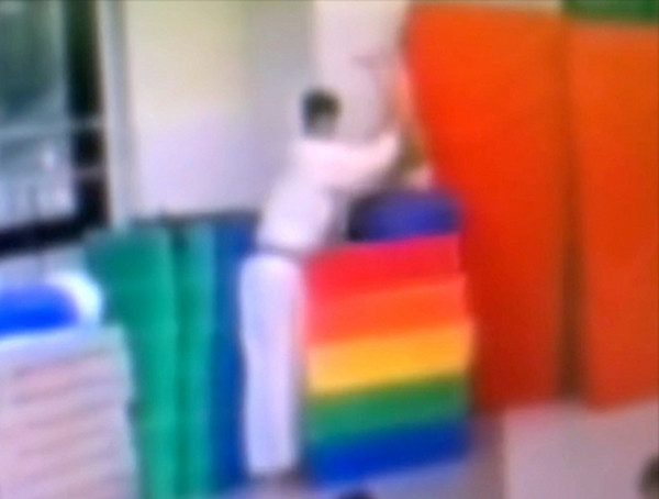 HLV ấn bé trai vào trong tấm thảm đã cuộn chặt. Ảnh: JTBC/ KoreaJoongAng Daily.