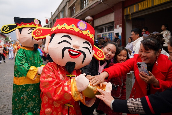 Người dân ở tỉnh Vân Nam (Trung Quốc) vui vẻ khi gặp diễn viên đóng vai Thần Tài vào ngày Thần Tài năm nay. Ảnh: CFP/ CGTN.