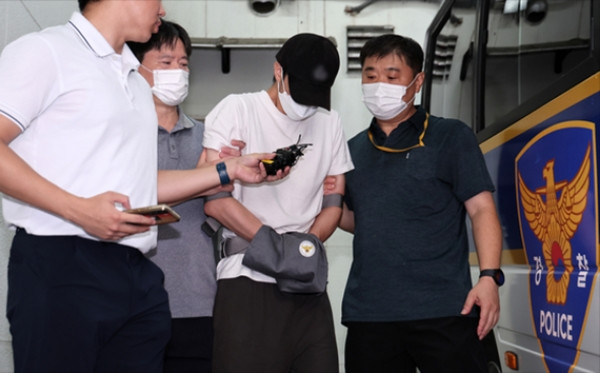 HLV bị cảnh sát dẫn giải. Ảnh: News1.