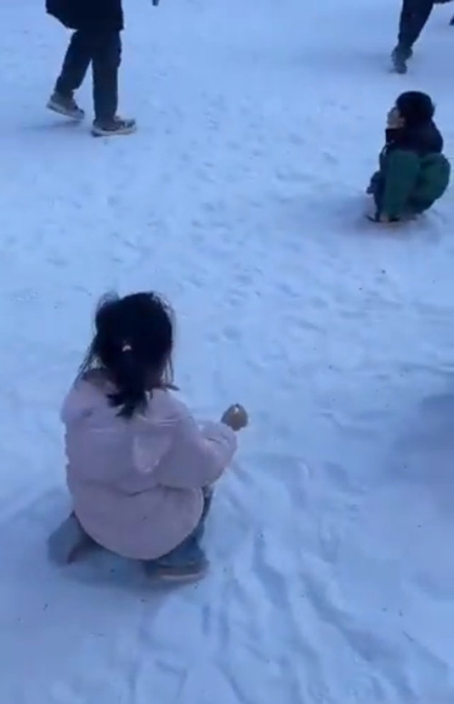 Trẻ em nghịch &quot;tuyết&quot;, thực ra là cát trắng. Ảnh: Newsflare.