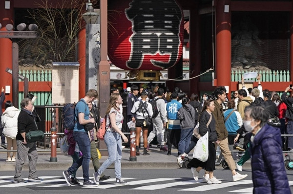 Nhiều du khách ở Tokyo (Nhật Bản) phải bỏ bớt áo khoác giữa lúc trời ấm/ nóng trái mùa vào tuần trước ở khắp nước Nhật. Ảnh: Kyodo.