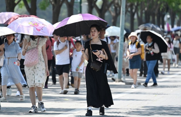 Người dân che ô dưới trời nắng nóng kỷ lục ở Bắc Kinh (Trung Quốc) vào mùa Hè 2023. Ảnh: AFP. Người dân che ô dưới trời nắng nóng kỷ lục ở Bắc Kinh (Trung Quốc) vào mùa Hè 2023. Ảnh: AFP.