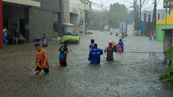 Người dân lội trong nước lụt ở Valenzuela City (gần Manila) vào sáng nay, 24/7. Ảnh: Andrew Rabulan/ Manila Standard.