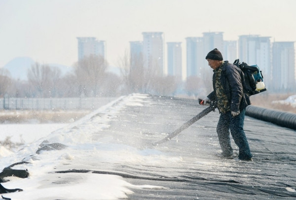 Một người đang dọn tuyết ở tỉnh Hà Bắc (Trung Quốc) trong một đợt rét đậm. Ảnh: Wang Xiao/ Xinhua.
