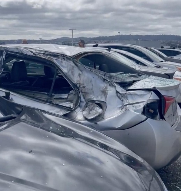 Một số ô tô bị hư hại do lốp máy bay từ trên cao rơi trúng. Ảnh: Julian.