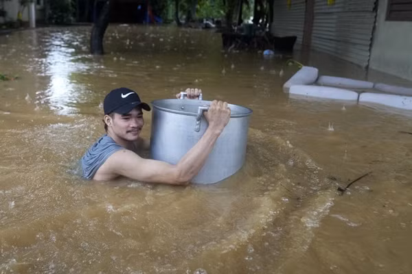 Một người dân ở tỉnh Rizal (Philippines) bám vào cái nồi khi lội trên đường phố ngập lụt vì mưa do bão Yagi (ở Philippines gọi là bão Enteng). Ảnh: Aaron Favila/ AP.