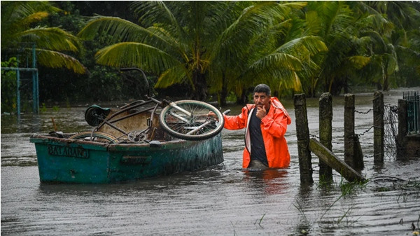 Một người dân ở Guanimar (Cuba) đẩy cái thuyền đựng đồ đạc của mình trên đường phố ngập lụt do ảnh hưởng của bão Helene vào ngày 25/9. Ảnh: Yamil Lage/ AFP via Getty Images. Một người dân ở Guanimar (Cuba) đẩy cái thuyền đựng đồ đạc của mình trên đường phố ngập lụt do ảnh hưởng của bão Helene vào ngày 25/9. Ảnh: Yamil Lage/ AFP via Getty Images.