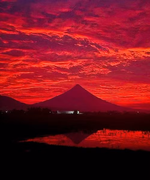 Bầu trời màu đỏ rực ở khu vực núi lửa Mayon (tỉnh Albay, Philippines) vào sáng 14/11. Ảnh: Nino Adonis Rebeta.