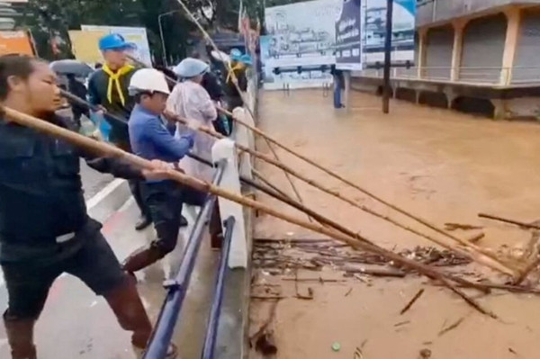 Nhiều người cùng cố loại bỏ những mảnh vụn từ bên dưới một cây cầu giữa ngập lụt do ảnh hưởng của bão Yagi ở tỉnh Chiang Rai (Thái Lan). Ảnh: Tubjaotak Task Force, Pha Muang Force/ Handout via REUTERS. Nhiều người cùng cố loại bỏ những mảnh vụn từ bên dưới một cây cầu giữa ngập lụt do ảnh hưởng của bão Yagi ở tỉnh Chiang Rai (Thái Lan). Ảnh: Tubjaotak Task Force, Pha Muang Force/ Handout via REUTERS.