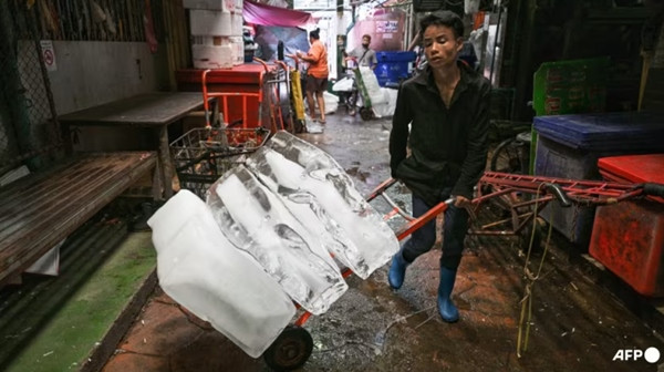 Nắng nóng khốc liệt đang bao trùm Đông Nam Á. Trong hình là một người đang di chuyển những cục đá lớn giữa lúc trời nóng ở Bangkok (Thái Lan). Ảnh: Lillian SUWANRUMPHA/ AFP.