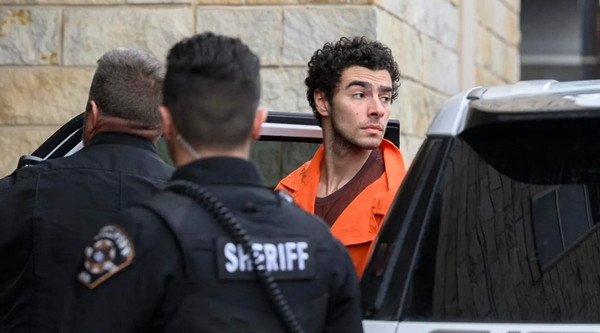 Mangione (áo cam) bị cảnh sát áp giải. Ảnh: Getty Images. Mangione (áo cam) bị cảnh sát áp giải. Ảnh: Getty Images.
