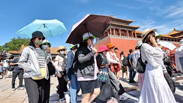 Du khách che nắng trong một đợt nóng ở Bắc Kinh (Trung Quốc) vào tháng 6/2024. Ảnh: Visual China Group/ Getty Images.