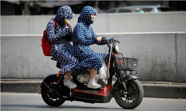 Người dân Hà Nội che chắn khi ra đường vào lúc trời nắng. Ảnh: Luong Thai Linh/ EPA. Người dân Hà Nội che chắn khi ra đường vào lúc trời nắng. Ảnh: Luong Thai Linh/ EPA.