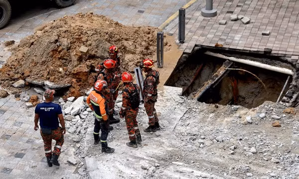 Các nhân viên cứu hỏa và cứu hộ ở Malaysia đang xem xét hố sụt thứ nhất ở Kuala Lumpur, nơi một nữ du khách Ấn Độ đã bị ngã xuống và đến giờ chưa được tìm thấy. Ảnh: Fazry Ismail/ EPA.