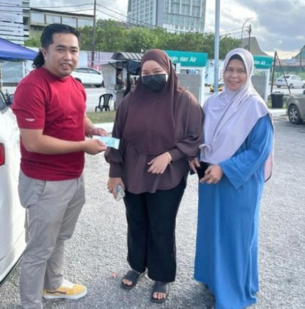 Tuah (trái) đã trao lại tờ tiền kỷ niệm cho Hidayah (giữa). Ảnh: Tuah Lim.