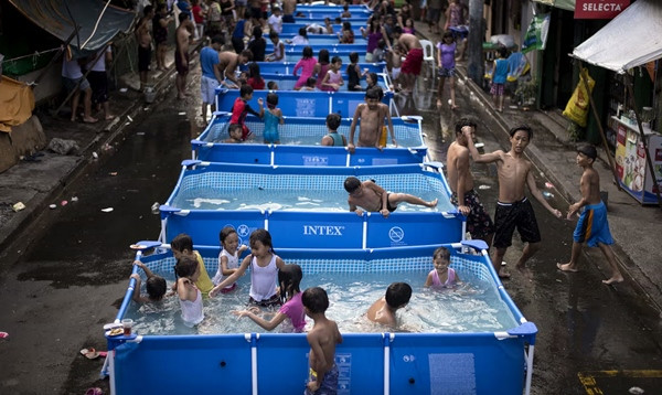 Trẻ em chơi trong các bể nước nhỏ để chống nóng ở Manila (Philippines). Ảnh: Noel Celis/ AFP/ Getty Images. Trẻ em chơi trong các bể nước nhỏ để chống nóng ở Manila (Philippines). Ảnh: Noel Celis/ AFP/ Getty Images.