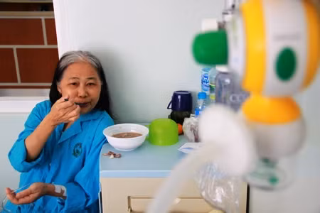 Bà Cúc ăn xuất cháo miễn phí của bệnh viện