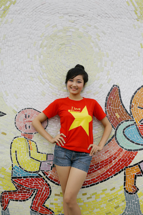 Sắc đỏ của áo hài hòa với những gam màu của bức tường gốm