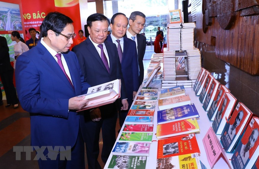 Thủ tướng Phạm Minh Chính cùng các đại biểu tham quan trưng bày sách Những bông hoa đẹp. (Ảnh: Dương Giang/TTXVN)