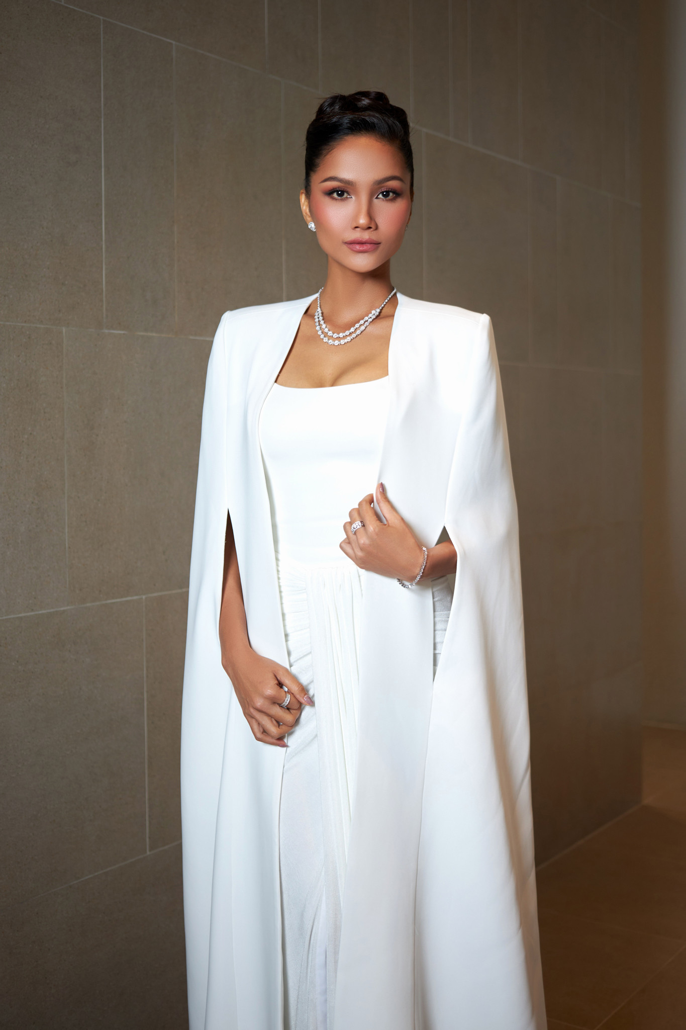 Hoa hậu H'Hen Niê xuất hiện trong ngày sơ khảo với tư cách giám khảo. Cô diện váy trắng, kèm áo choàng sang trọng.