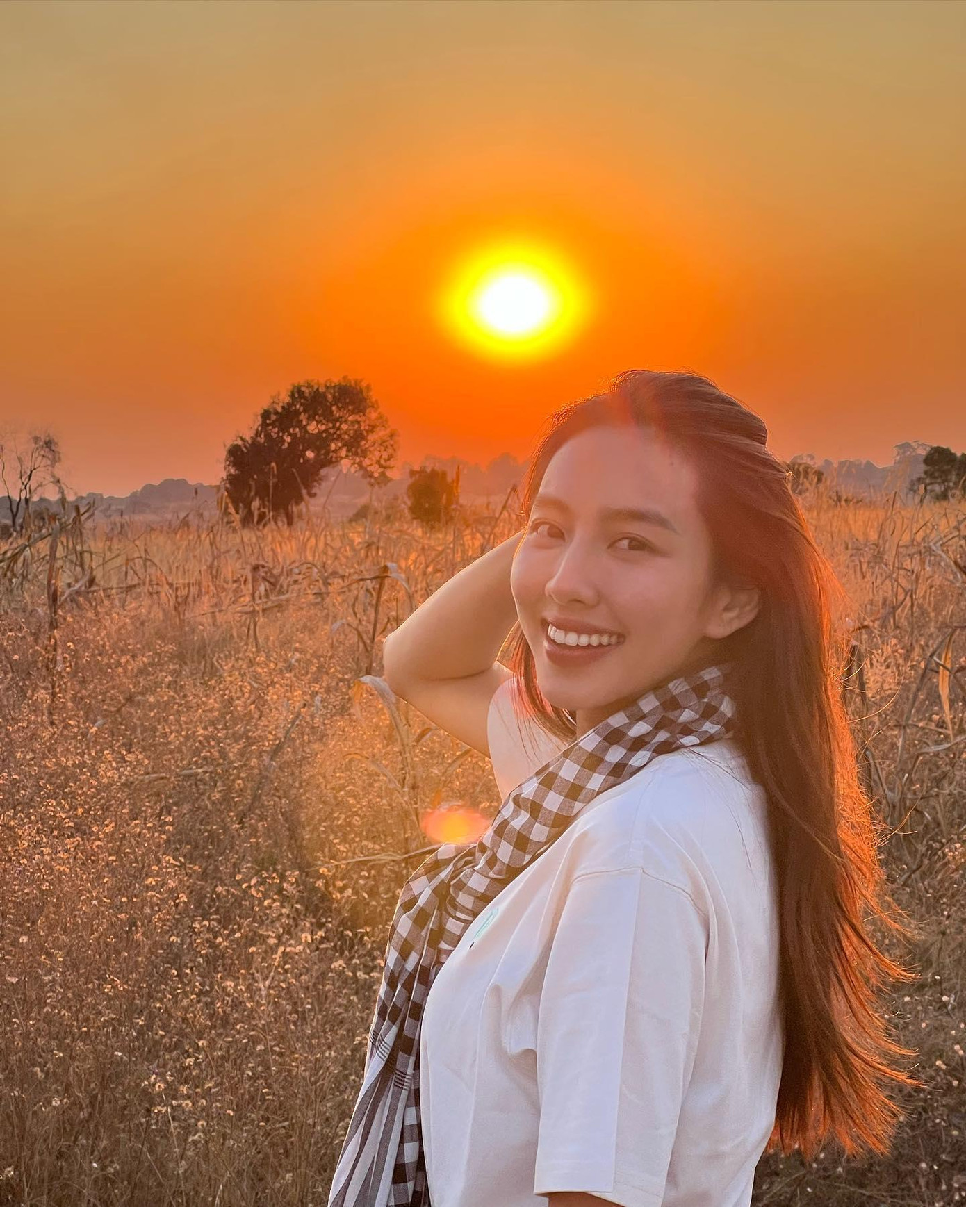 Cô giản dị với áo phông trắng và chiếc khăn rằn đặc trưng của Nam bộ. Cô giản dị với áo phông trắng và chiếc khăn rằn đặc trưng của Nam bộ.