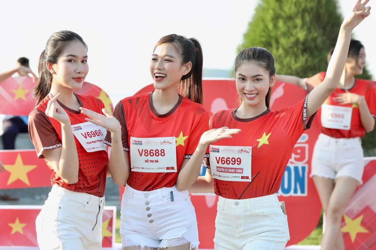 Mặc áo đồng phục và quần short trắng, ba người đẹp khoe vẻ đẹp năng động và rạng rỡ trên đường chạy marathon.