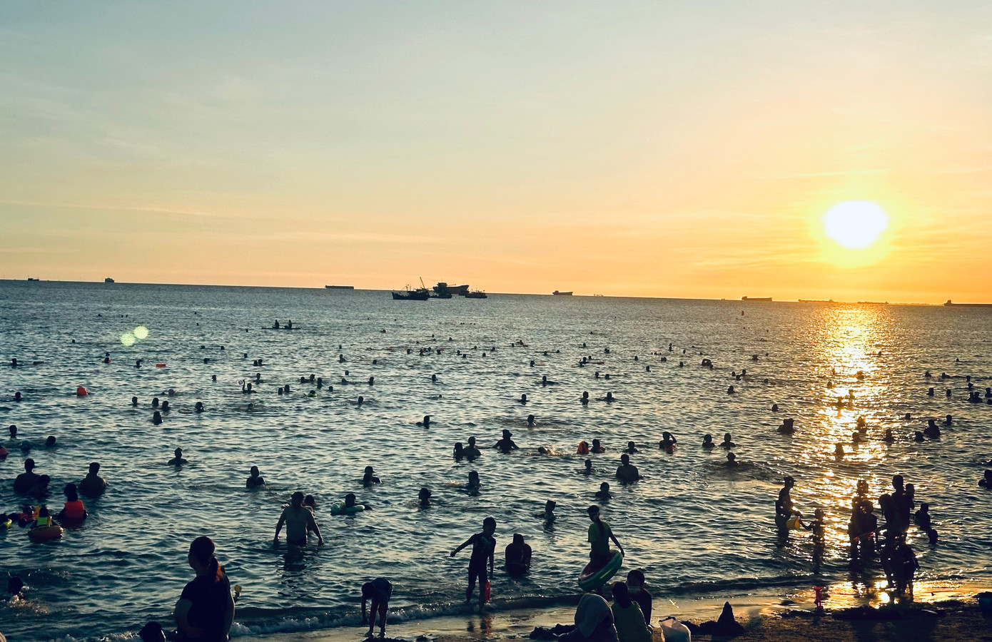 Mặt trời sắp lặn cũng là lúc người dân đổ ra tắm biển đông hơn