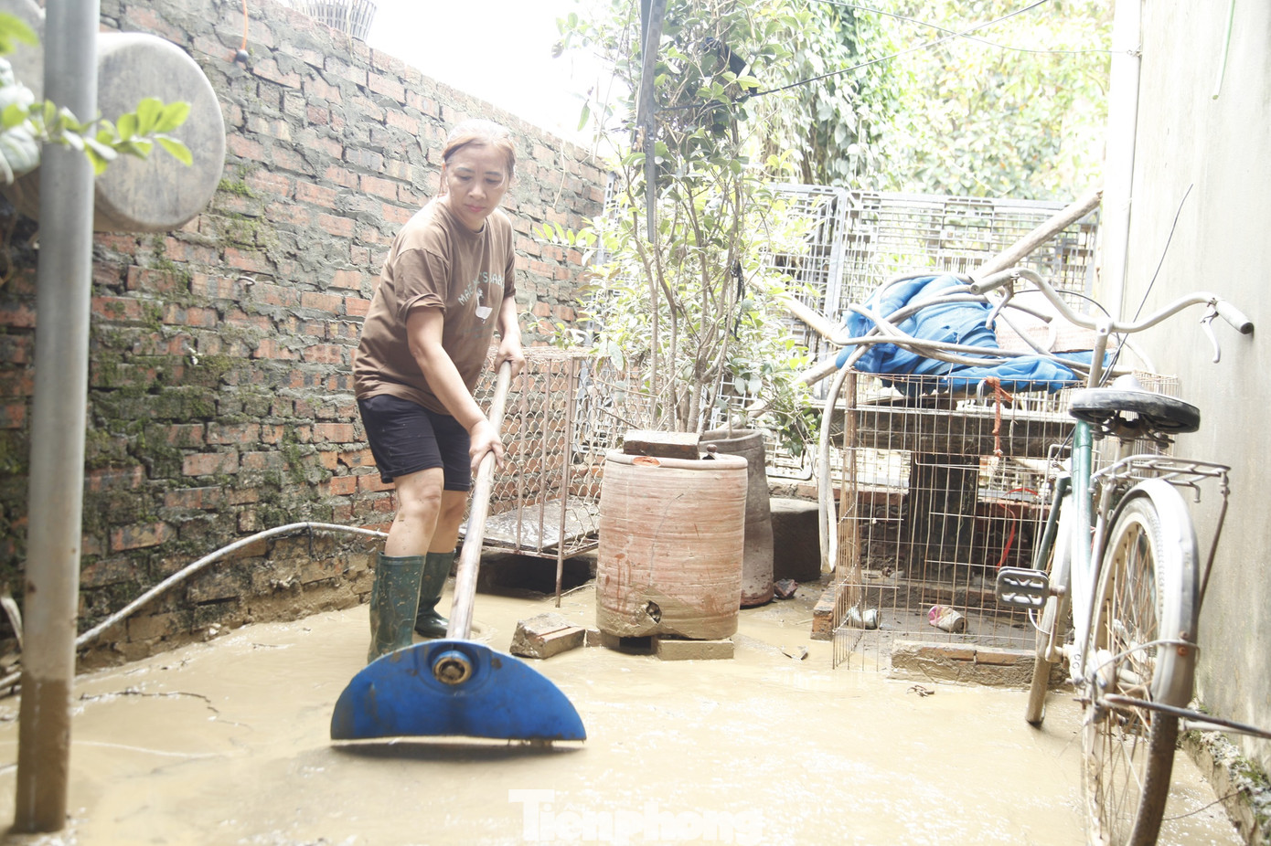 Người dân xã Vân Hà thu dọn bùn đất trong nhà khi nước lũ rút. Ảnh: Nguyễn Thắng.