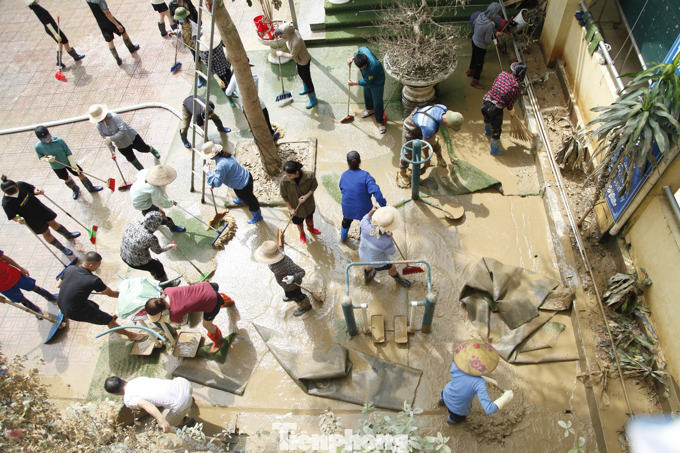 Người dân xã Vân Hà và tình nguyện viên thu dọn trường học để đón các em học sinh đến lớp khi nước lũ bắt đầu rút. Ảnh: Nguyễn Thắng.