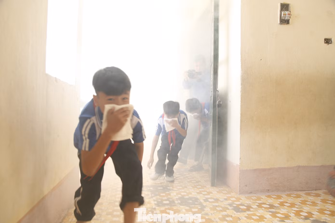 Công an hướng dẫn các em học sinh thoát khỏi đám cháy có nhiều khói. Ảnh: Nguyễn Thắng