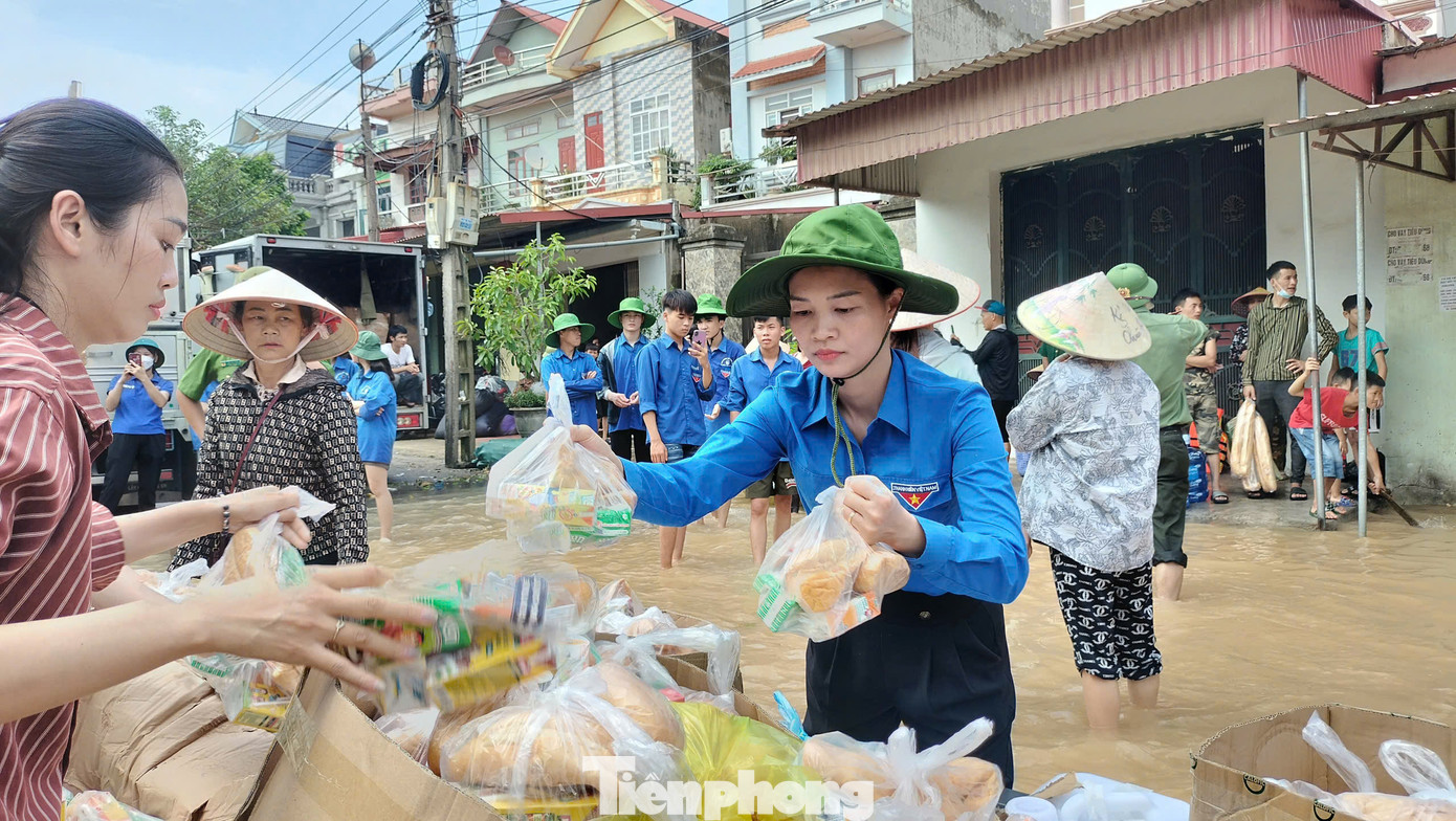 Chị Nguyễn Thị Hương - Bí thư Huyện Đoàn Yên Dũng (Bắc Giang) tiếp tế lương thực, thực phẩm cho bà con vùng lũ. Ảnh: Nguyễn Thắng