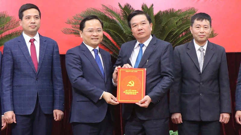 Bí thư Tỉnh ủy Bắc Ninh Nguyễn Anh Tuấn (bên trái) trao quyết định cho ông Hà Sỹ Tiếp.