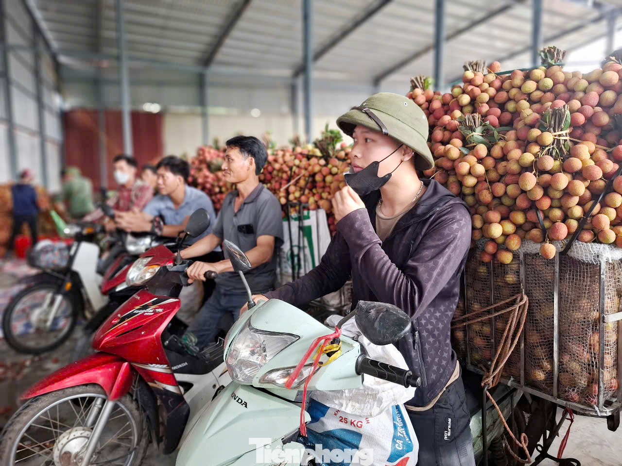 Người dân chờ cân vải thiều để bán vào miền Nam ở một điểm cân ven quốc lộ 31 tại thị xã Chũ (tỉnh Bắc Giang).