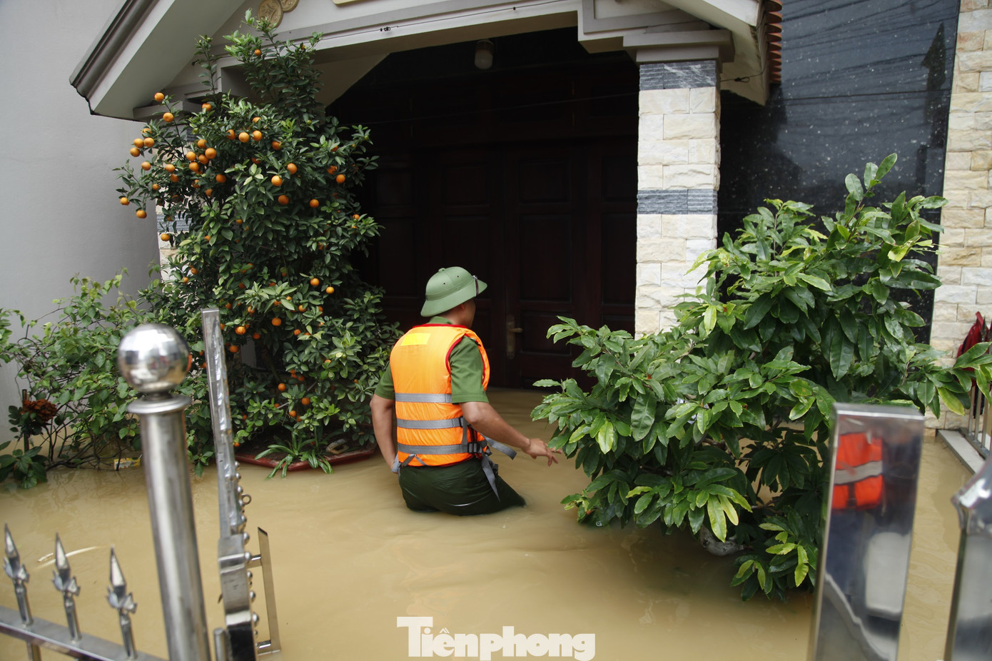 Chiến sĩ công an lội nước vào từng nhà dân để đón người dân di chuyển đến nơi an toàn. Ảnh: Nguyễn Thắng