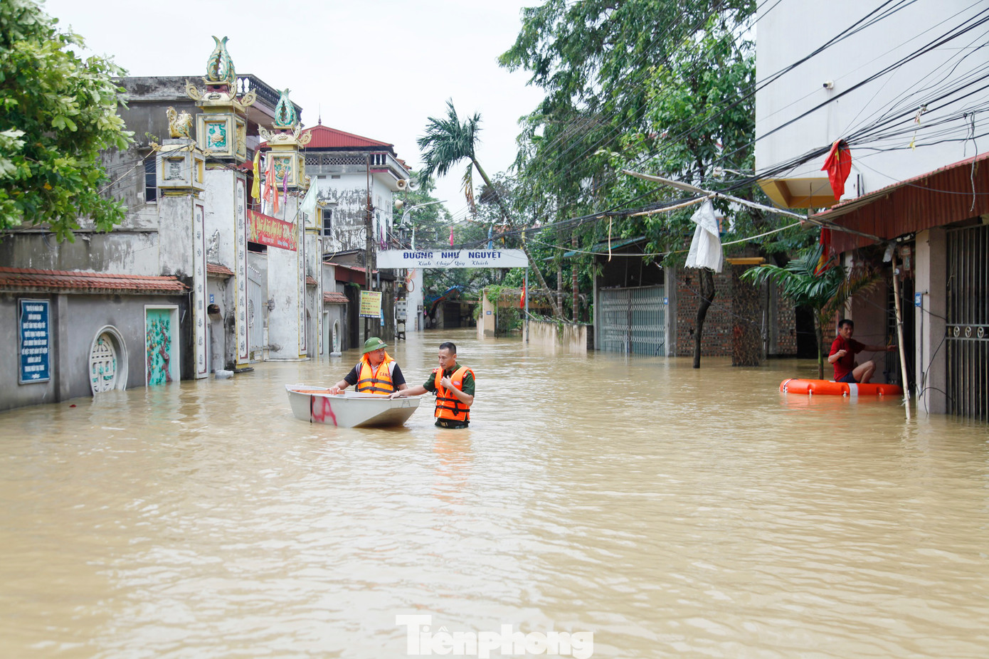 Nhiều chiến sĩ công an lội nước đưa người dân ra khỏi vùng lũ. Ảnh: Nguyễn Thắng
