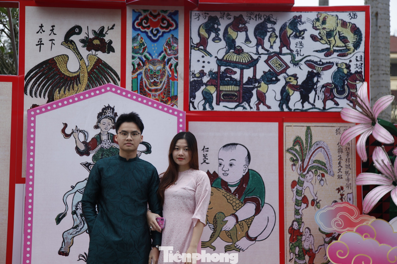 Đường hoa Tết ở thành phố Bắc Ninh có hơn 20 tiểu cảnh, mô hình trang trí tái hiện văn hóa Kinh Bắc được thiết kế bằng chất liệu chính là mây tre đan truyền thống và lấy cảm hứng từ nón quai thao, dải lụa đào. Các bạn trẻ chụp ảnh với mô hình tranh Đông Hồ. Ảnh: Nguyễn Thắng