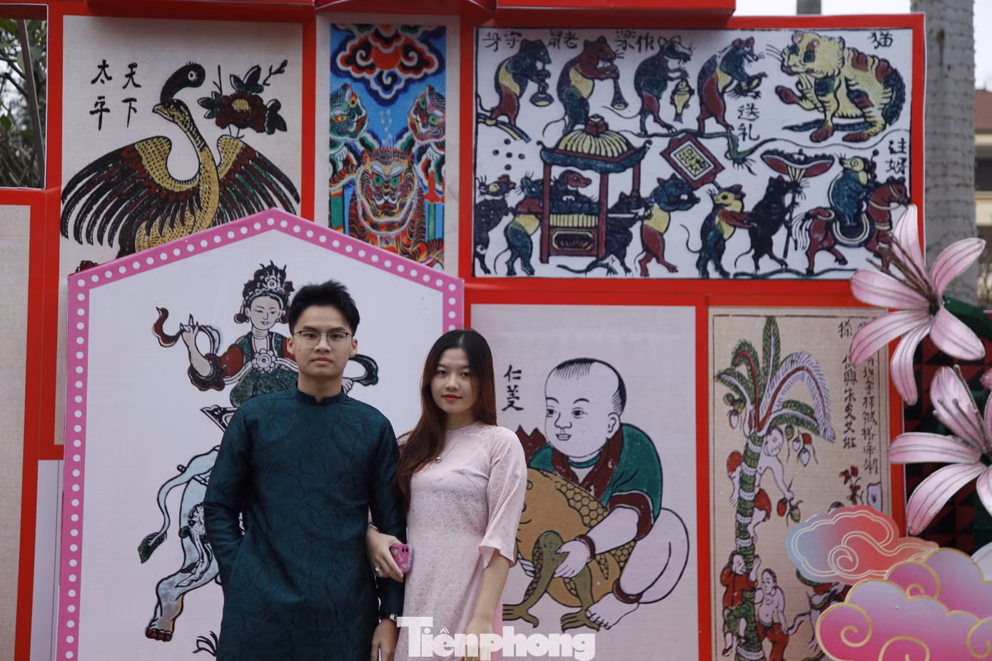 Đường hoa Tết ở thành phố Bắc Ninh có hơn 20 tiểu cảnh, mô hình trang trí tái hiện văn hóa Kinh Bắc được thiết kế bằng chất liệu chính là mây tre đan truyền thống và lấy cảm hứng từ nón quai thao, dải lụa đào. Các bạn trẻ chụp ảnh với mô hình tranh Đông Hồ. Ảnh: Nguyễn Thắng