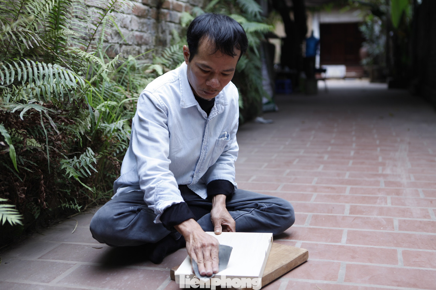 Anh Thạo đánh bóng gỗ thị trước khi khắc mộc bản. Năm nay, anh bước sang tuổi 50. Năm 16 tuổi, anh khăn gói đến Đồng Kỵ (thành phố Từ Sơn, tỉnh Bắc Ninh) để theo nghề chạm trổ gỗ mỹ nghệ. Ảnh: Nguyễn Thắng