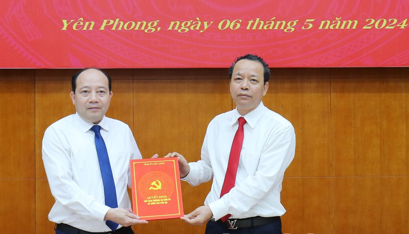 Phó Bí thư Thường trực Tỉnh ủy Bắc Ninh Nguyễn Quốc Chung (bên phải) trao quyết định bổ nhiệm cho ông Huy.