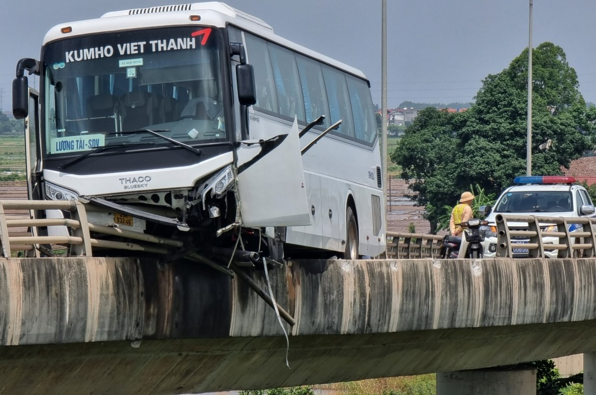 Xe ô tô chở công nhân mất lái lao lên thành cầu Bình Than.