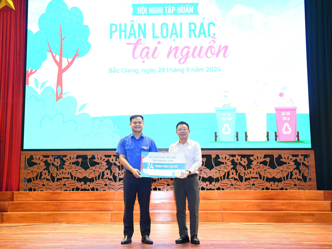 Tổng Biên tập báo Tiền Phong Phùng Công Sưởng (phải) trao tặng Tỉnh Đoàn Bắc Giang 24 thùng rác để thực hiện thí điểm phân loại tại nguồn.