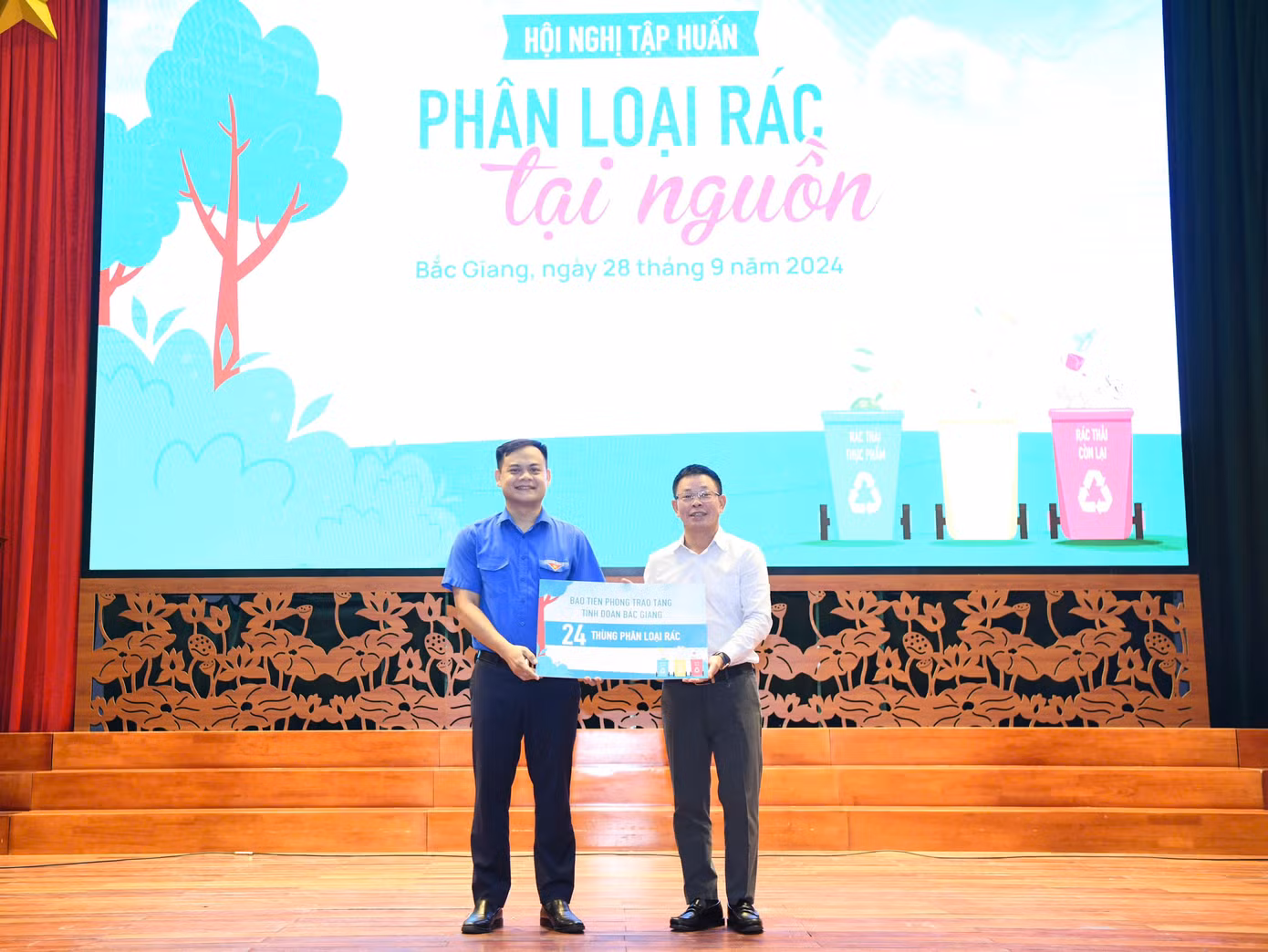 Tổng Biên tập báo Tiền Phong Phùng Công Sưởng (phải) trao tặng Tỉnh Đoàn Bắc Giang 24 thùng rác để thực hiện thí điểm phân loại tại nguồn.