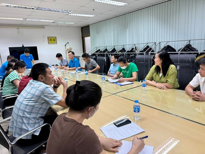 Cơ quan chức năng và Công ty TNHH KD Sports Việt Nam làm việc giải quyết việc công nhân ngừng việc. Ảnh: LĐ.