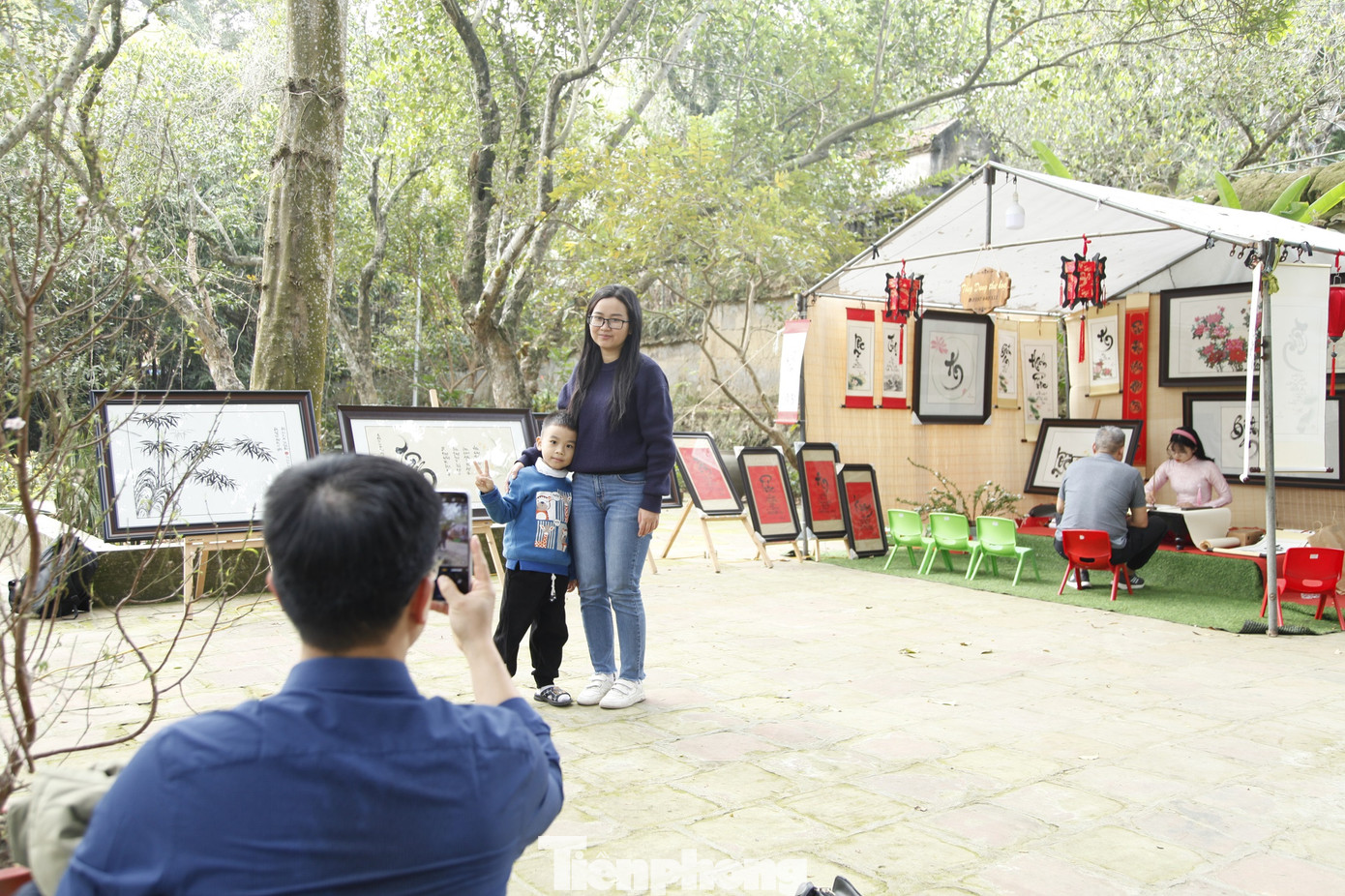 Nhiều người chụp ảnh kỷ niệm tại khu vực viết chữ thư pháp ở chùa Bổ Đà. Ảnh: Nguyễn Thắng