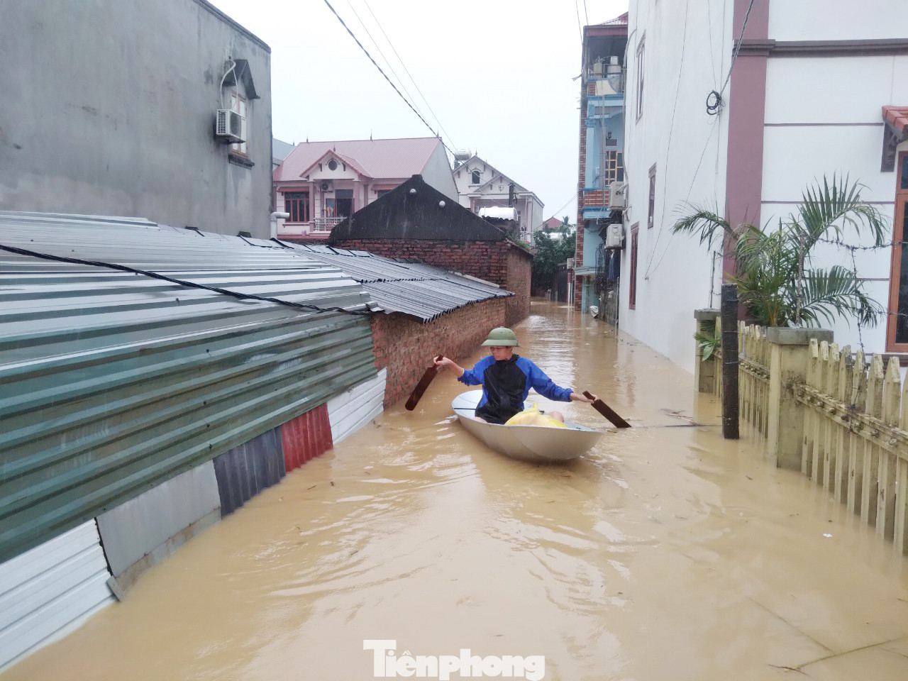 Người dân bơi thuyền ra nhận lương thực, thực phẩm. Ảnh: Nguyễn Thắng