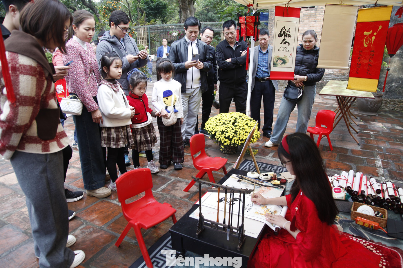 Du khách đến chùa Bổ Đà thích thú xem cô đồ viết thư pháp. Ảnh: Nguyễn Thắng