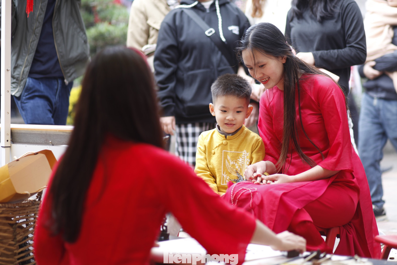 Hai mẹ con xem cô đồ viết thư pháp.