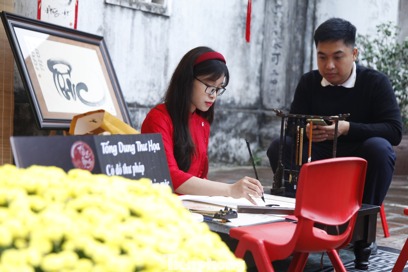 Cô đồ viết thư pháp thu hút sự chú ý với nhiều du khách thập phương đến chùa Bổ Đà.