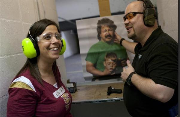 Một nữ giáo viên đang được huấn luyện viên súng hướng dẫn ngắm mục tiêu và bắn kẻ tấn công 